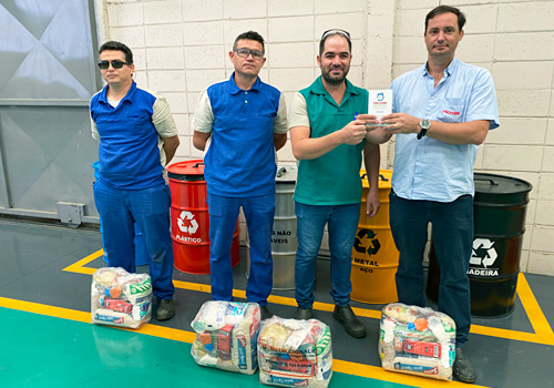 Entrega da premiação do 5S junto às lixeiras de coleta seletiva da fábrica